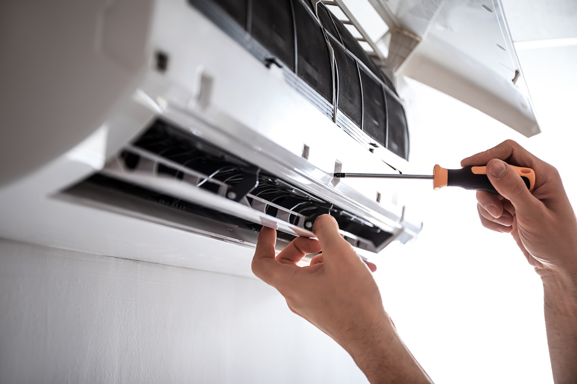 monteur die airco installeert met schroevendraaier